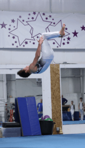 boy performing back tuck in gym