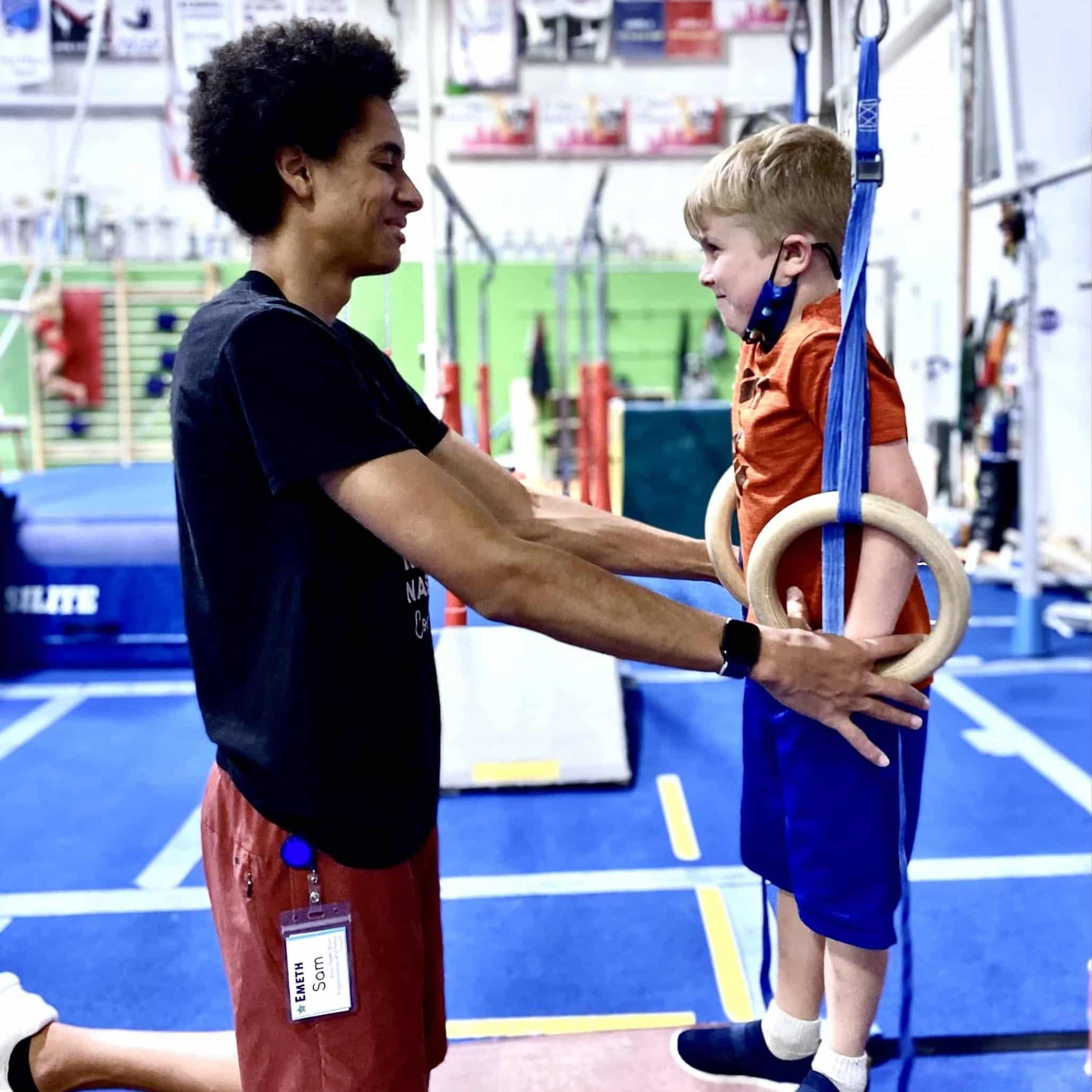 toddler / preschool gymnastics coach with boy on rings