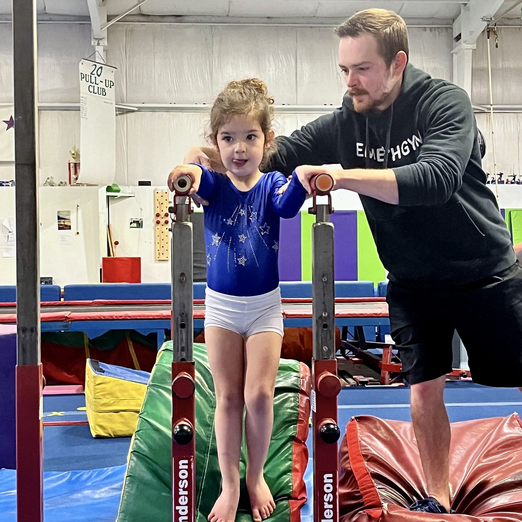 Toddler teacher with student on parallel bars
